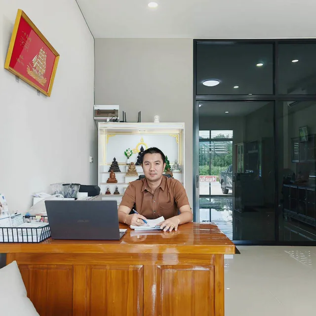 ทนายคมสัน แช่มช้อย นั่งทำงานที่โต๊ะภายในสำนักงานทนายความ